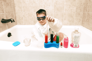Child playing science lab in the bathtub
