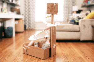 Handmade marble run made out of cardboard, paper plates, and water bottles.