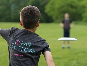 Two boys playing frisbee in field