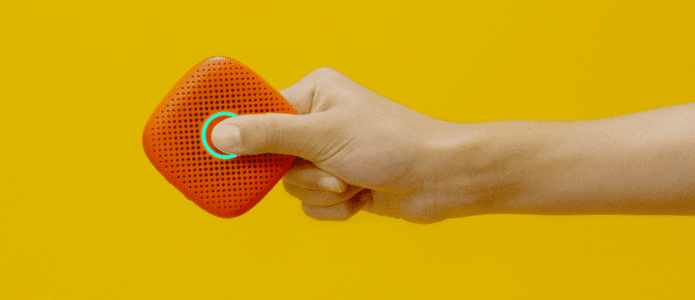 hand holds a brick red Relay in the air against a yellow background