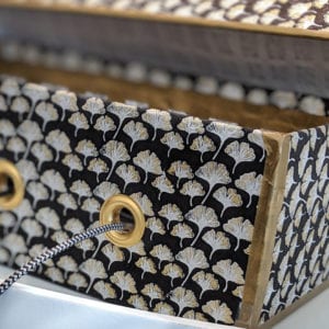 metal grommets in a paper-covered shoe box allow cords to go through
